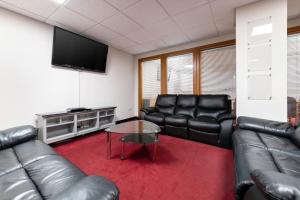 a living room with leather furniture and a flat screen tv at For Student Only City Living Studios in the heart of Coventry at Market Way in Coventry