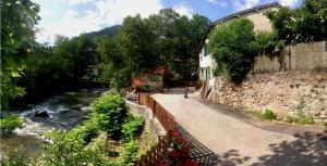 une personne se promenant sur un sentier à côté d'une rivière dans l'établissement Gîte du Grand Taïchou, à Luzenac