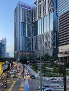 The platinum KLCC By Garden Suites في كوالالمبور: شارع المدينة مزدحم مع حركة المرور أمام المباني الطويلة