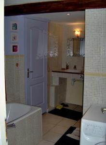 a bathroom with a white tub and a sink at Gîte du Grand Taïchou in Luzenac