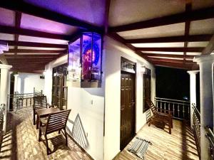 ElagawagodaにあるRanu Villa kathaluwaのバルコニー(テーブル、椅子、紫色の照明付)
