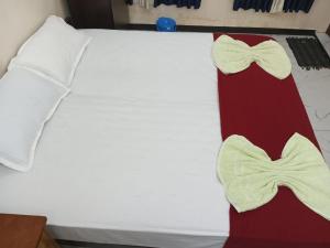 a bed with two bow ties on it at SRI PADMANABHA TOURIST HOME in Chacka