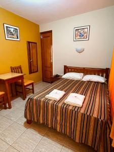 um quarto de hotel com uma cama com duas toalhas em Hostal El Pillkay em Trujillo