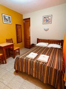 Una habitación de hotel con una cama con dos toallas. en Hostal El Pillkay, en Trujillo