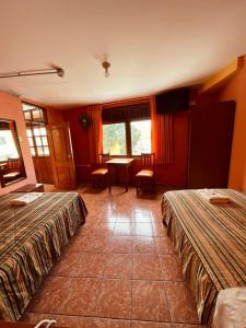 Hostal El Pillkay في تروخيو: غرفة فندقية بسريرين وطاولة