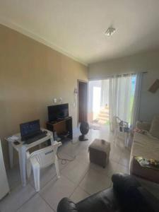 a living room with a couch and a table with a laptop at Casa dos Pirineus in Tibau do Sul