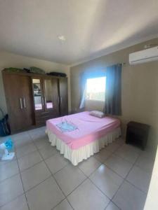 a bedroom with a pink bed in a room at Casa dos Pirineus in Tibau do Sul