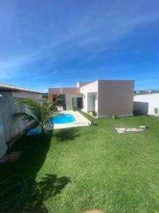 a house with a green yard with a swimming pool at Casa dos Pirineus in Tibau do Sul