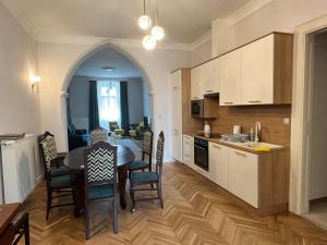 eine Küche und ein Esszimmer mit einem Tisch und Stühlen in der Unterkunft Ady1 Apartment in Kaposvár