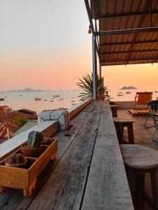 a wooden table with a view of the ocean at Sattahiptale Boutique Guesthouse & Hostel in Sattahip