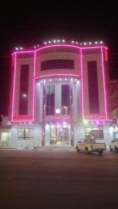 a pink building with a car parked in front of it at شقق روز شروره للشقق المخدومة in Sharurah