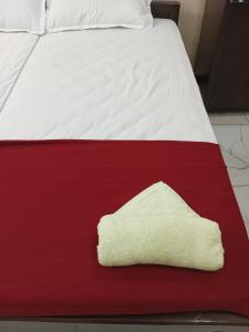 a red and white bed with a towel on it at SRI PADMANABHA TOURIST HOME in Chacka