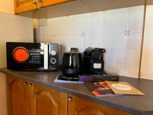 a kitchen counter with a microwave and a coffee maker at Cozy Penthouse 2 bedrooms with WiFi - Netflix - Private Parking in Tarvisio