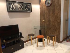 a room with a table and two stools and a tv at 1BR Condo Unit W/ Fantastic View near US Embassy in Manila