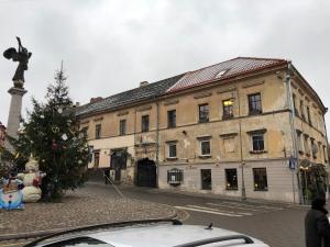 un viejo edificio con un árbol de Navidad delante de él en Uzupis Angel 3 bedroom Apartment, en Vilna