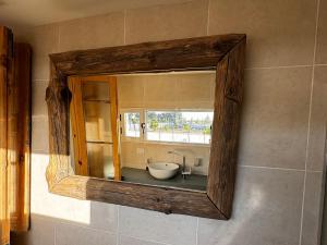 a mirror on a wall with a sink in a bathroom at Estancia TATAY in Trelew +43 photos