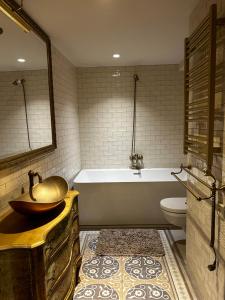 a bathroom with a tub and a sink and a toilet at Uzupis Angel 3 bedroom Apartment in Vilnius