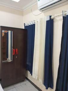 a bathroom with blue and white curtains and a cabinet at SRI PADMANABHA TOURIST HOME in Chacka