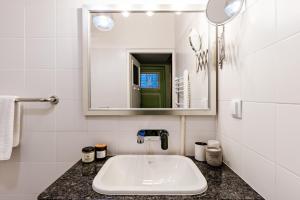 La salle de bains blanche est pourvue d'un lavabo et d'un miroir. dans l'établissement Gdańsk Old Town Apartment by ECRU GDA1, à Gdańsk