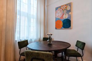 - une table à manger avec des chaises et un vase fleuri dans l'établissement Gdańsk Old Town Apartment by ECRU GDA1, à Gdańsk