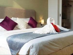 The platinum KLCC By Garden Suites في كوالالمبور: تمثال للعرسان والعريس جالس فوق السرير