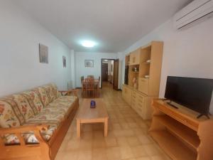 a living room with a couch and a flat screen tv at Rentalmar Sol de España - Mas d'en Gran in Cambrils