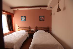 2 Betten in einem Zimmer mit Fenster in der Unterkunft Yangshuo Xiao Long River Hotel in Yangshuo