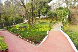 a red brick walkway in a park with plants at Chirping Hills Resort,Bhimtal in Bhīm Tāl