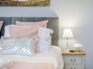 a bedroom with a bed with pink and white pillows at 1 Bed in Sennen 85836 in St Just