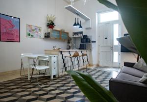 a kitchen and living room with a table and chairs at Casa Orchidea - The Fab Stay in Brindisi