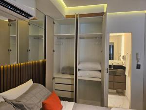 a bedroom with a closet with a bed and a mirror at Apto novo no centro de São Paulo c/Garagem in Sao Paulo