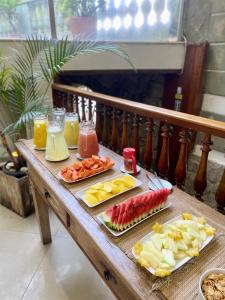 a wooden table with fruit and juice on it at Pousada Casa Imperatriz - Rua Teresa in Petrópolis