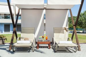 two chairs and a table under a gazebo at Iris Hotel in Siviri