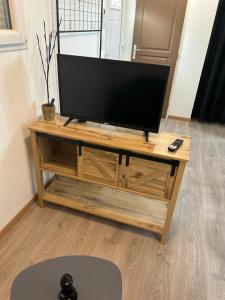 a flat screen tv sitting on top of a wooden entertainment center at Bienvenu chez nous in Douzens