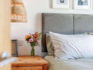 a vase of flowers on a table next to a bed at 2 Bed in Bude 5.6mls N 86909 in Kilkhampton