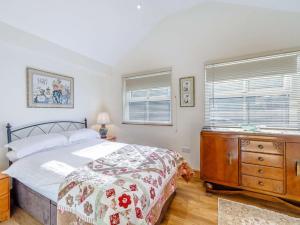 a bedroom with a bed and a dresser and two windows at 3 Bed in Rowlands Gill 86802 in Stanley