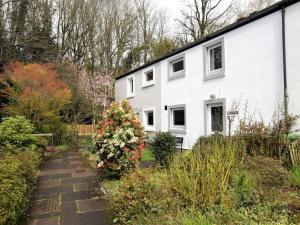 a white house with a garden in front of it at 2 Bed in Keswick 87092 in Keswick