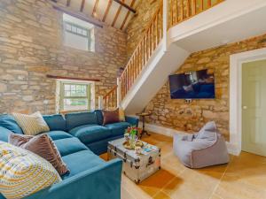 a living room with a blue couch and a stone wall at 6 Bed in Hexham 87253 in Dalton