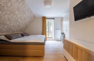 1 dormitorio con 1 cama y TV en la pared en Ferienwohnungen in Wald und Flur - Wohnung Flur, en Lüder