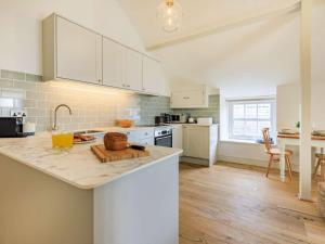 une cuisine avec des placards blancs et un comptoir dans l'établissement 1 Bed in Charmouth 87527, à Charmouth