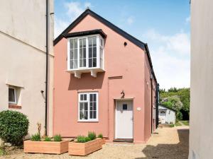ein rosa Haus mit einer weißen Tür in der Unterkunft 1 Bed in Charmouth 87529 in Charmouth