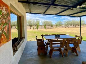 a patio with a table and chairs and a field at Estancia TATAY in Trelew