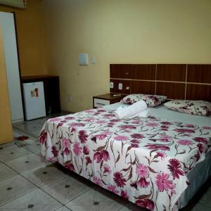 阿爾特做超的住宿－Pousada Cunhantã，一间卧室配有一张带花卉床罩的大床