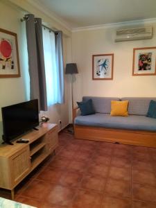 uma sala de estar com um sofá e uma televisão em Apartamento Alagoa Azul em Altura