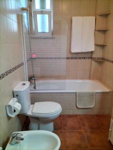 a bathroom with a toilet and a tub and a sink at Apartamento Alagoa Azul in Altura