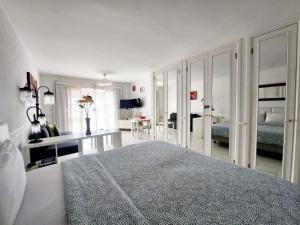 ロス・クリスティアーノスにあるPorto Royaleの白いベッドルーム(ベッド1台付)、リビングルーム
