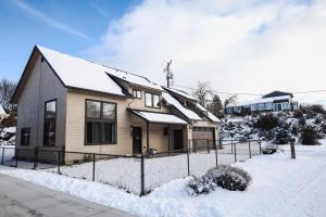 a house with a fence in the snow at Lepista Landing Family Home Near Downtown KFalls in Klamath Falls