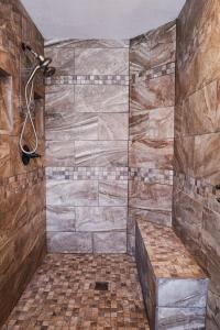 a bathroom with a shower with a stone wall at Lepista Landing Family Home Near Downtown KFalls in Klamath Falls