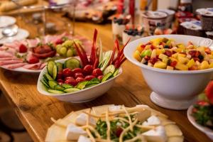 uma mesa de madeira coberta com tigelas de frutas e legumes em Pension Adalbert em Cesky Krumlov