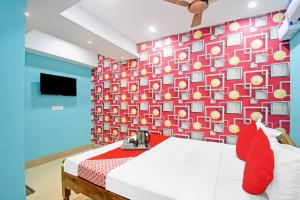 a room with a bed and a wall with a wallpaper at SPOT ON Lewis Paradise in Bhubaneshwar